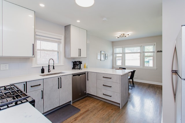 5246 N Mason Ave, Chicago, IL 60630 - kitchen with stainless steel dishwasher, freestanding refrigerator, a peninsula, wood finished floors, and light countertops