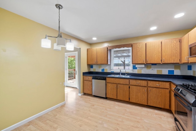 913 S Bentley Rd, New Lenox, IL 60451 - kitchen featuring appliances with stainless steel finishes, light wood finished floors, dark countertops, pendant lighting, and brown cabinetry