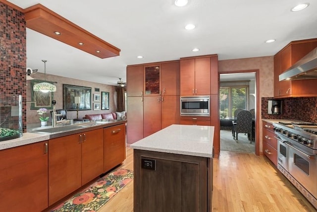 8850 Karlov Ave, Skokie, IL 60076 - kitchen featuring stainless steel appliances, light wood finished floors, recessed lighting, decorative backsplash, and light stone countertops