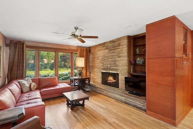 8850 Karlov Ave, Skokie, IL 60076 - living room with a ceiling fan, light wood-style floors, and a stone fireplace