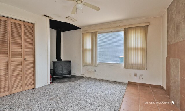 143 Eagle Point Rd, Fox Lake, IL 60020 - unfurnished living room with a wood stove and ceiling fan