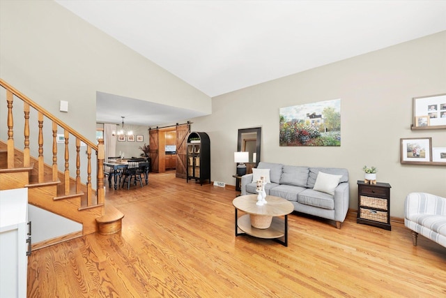 9912 S Kolmar Ave, Oak Lawn, IL 60453 - living room with a barn door, light wood finished floors, high vaulted ceiling, stairway, and a chandelier