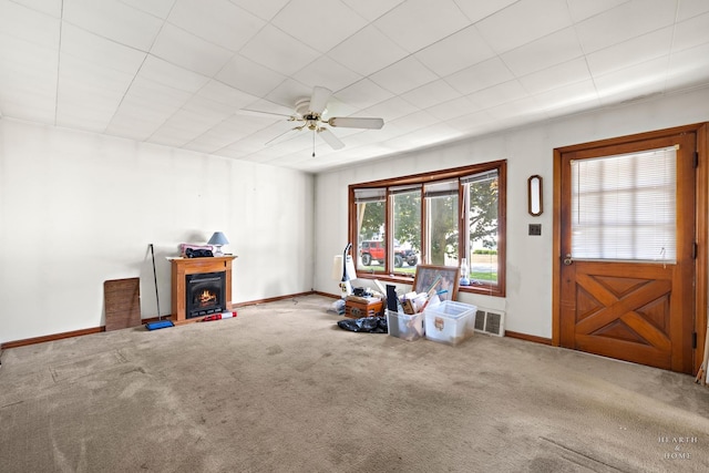 3715 Maple Ave, Mchenry, IL 60050 - carpeted living area with a lit fireplace and ceiling fan