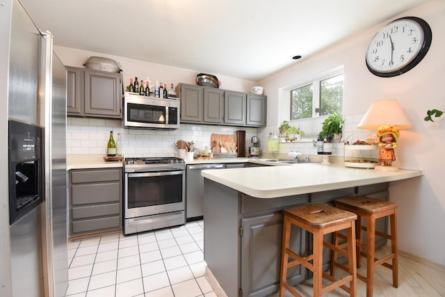 801 S Plymouth Ct Unit V, Chicago, IL 60605 - kitchen featuring stainless steel appliances, gray cabinetry, a peninsula, and backsplash