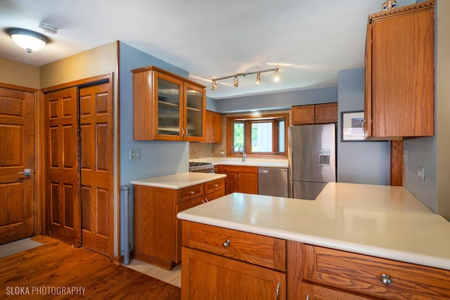 530 Sunnyside Ave, Gurnee, IL 60031 - kitchen with appliances with stainless steel finishes, brown cabinetry, glass insert cabinets, light wood-type flooring, and light countertops