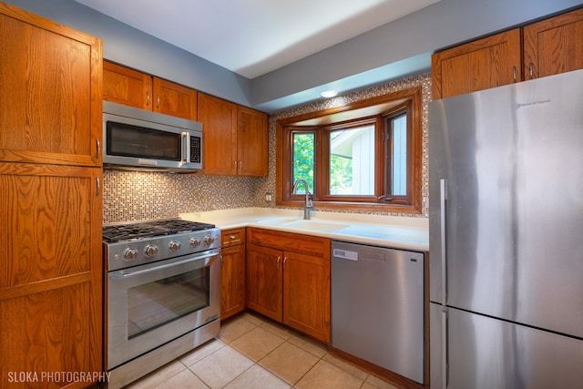 530 Sunnyside Ave, Gurnee, IL 60031 - kitchen with appliances with stainless steel finishes, brown cabinetry, light countertops, light tile patterned floors, and decorative backsplash