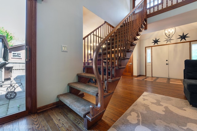 530 Sunnyside Ave, Gurnee, IL 60031 - staircase featuring a chandelier, wood-type flooring, and a high ceiling