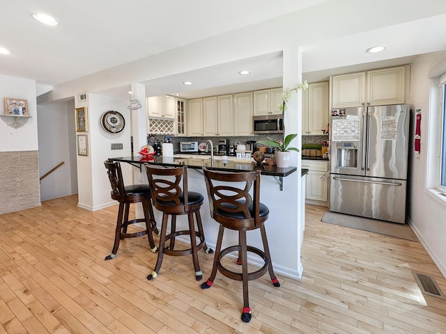 204 Inverrary Ln, Deerfield, IL 60015 - kitchen with stainless steel appliances, cream cabinets, decorative backsplash, dark countertops, and recessed lighting