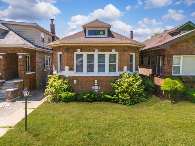 8510 S Blackstone Ave, Chicago, IL 60619 - bungalow-style home featuring brick siding, a front lawn, and a shingled roof