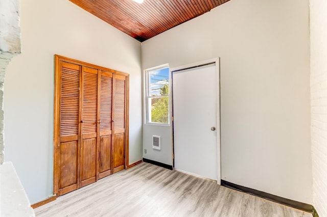 8510 S Blackstone Ave, Chicago, IL 60619 - unfurnished bedroom with light wood finished floors, wood ceiling, a closet, and heating unit