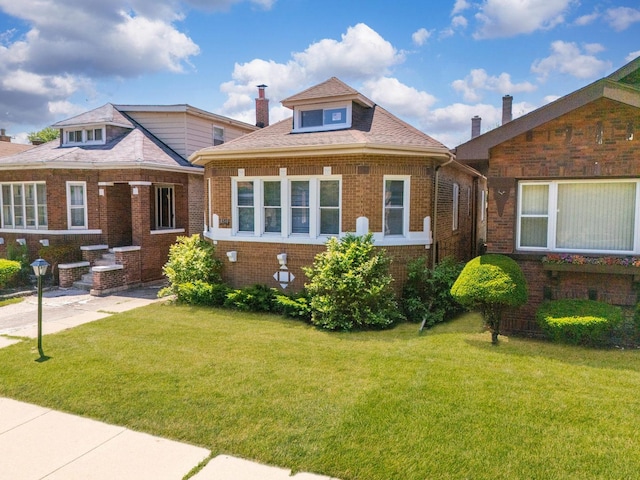 8510 S Blackstone Ave, Chicago, IL 60619 - view of front of house featuring brick siding, a front yard, and a chimney
