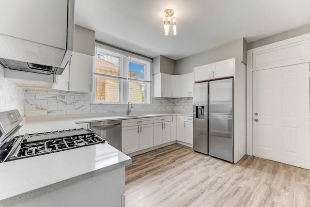 8510 S Blackstone Ave, Chicago, IL 60619 - kitchen with appliances with stainless steel finishes, decorative backsplash, light wood-style floors, and white cabinets