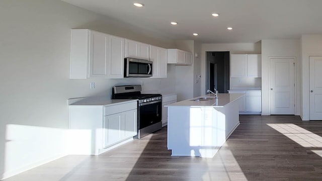 6475 Juniper Dr, Wonder Lake, IL 60097 - kitchen featuring appliances with stainless steel finishes, white cabinets, recessed lighting, wood finished floors, and a kitchen island with sink
