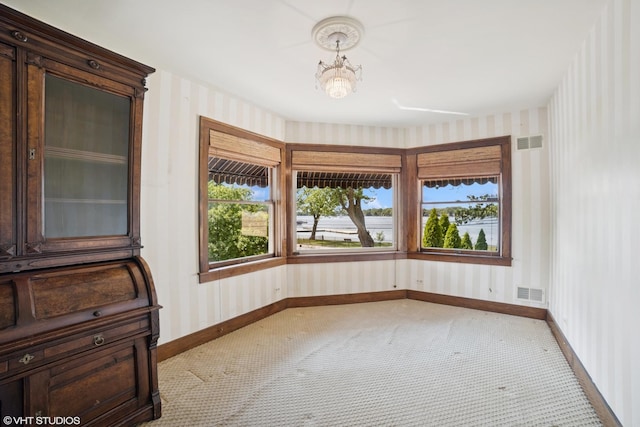 691 Lake Ave, Crystal Lake, IL 60014 - carpeted spare room featuring wallpapered walls and a chandelier