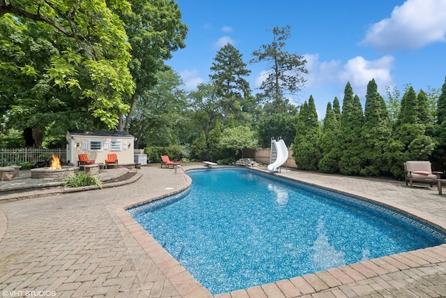 691 Lake Ave, Crystal Lake, IL 60014 - view of pool featuring an outdoor fire pit, a water slide, a patio area, a diving board, and a fenced backyard