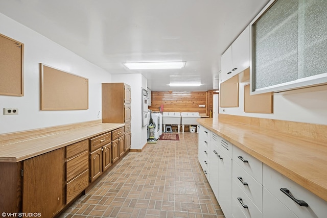 691 Lake Ave, Crystal Lake, IL 60014 - kitchen featuring brick patterned floors, white cabinetry, butcher block counters, and a peninsula