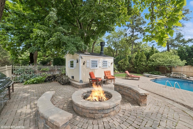691 Lake Ave, Crystal Lake, IL 60014 - fenced backyard featuring a fire pit, a patio, an outdoor structure, and view of scattered trees