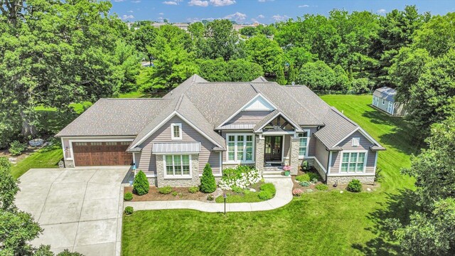 1311 Hickory Tree Ct, Mahomet, IL 61853 - craftsman-style home with stone siding, concrete driveway, a front yard, and a garage