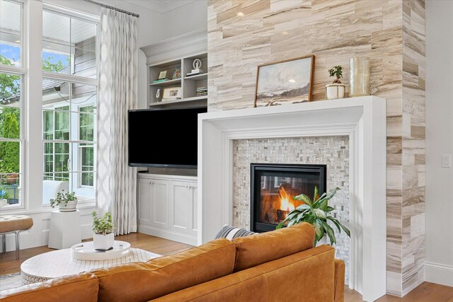 1311 Hickory Tree Ct, Mahomet, IL 61853 - living room with wood finished floors, ornamental molding, a tile fireplace, and built in features
