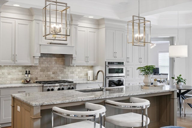 1311 Hickory Tree Ct, Mahomet, IL 61853 - kitchen with a chandelier, stainless steel double oven, tasteful backsplash, a kitchen breakfast bar, and hanging light fixtures