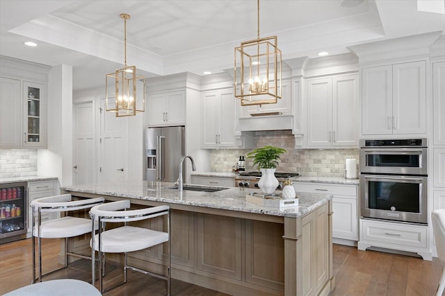 1311 Hickory Tree Ct, Mahomet, IL 61853 - kitchen with appliances with stainless steel finishes, a chandelier, a raised ceiling, wine cooler, and recessed lighting