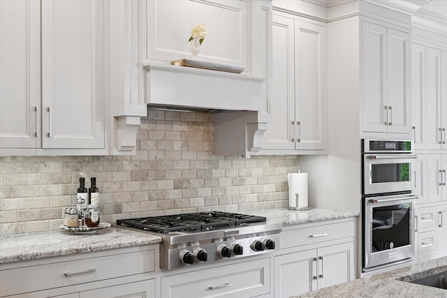 1311 Hickory Tree Ct, Mahomet, IL 61853 - kitchen featuring stainless steel appliances, white cabinets, tasteful backsplash, and light stone counters