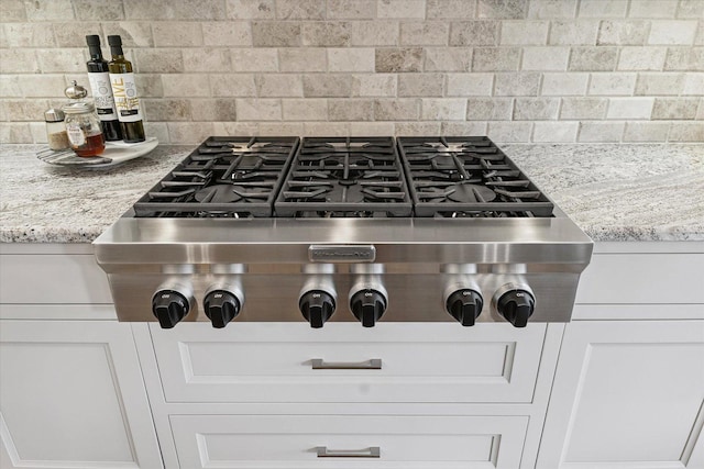 1311 Hickory Tree Ct, Mahomet, IL 61853 - kitchen view of stainless steel gas cooktop, backsplash, and light stone countertops