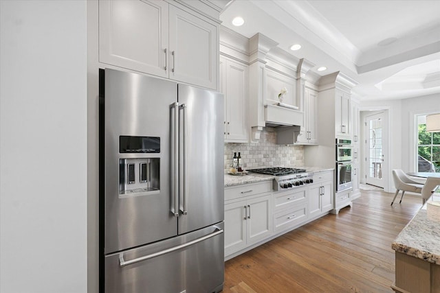 1311 Hickory Tree Ct, Mahomet, IL 61853 - kitchen with stainless steel appliances, light wood-style floors, decorative backsplash, white cabinets, and recessed lighting