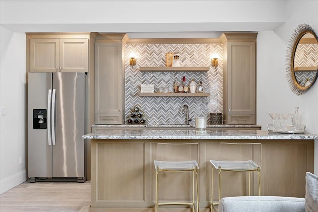 1311 Hickory Tree Ct, Mahomet, IL 61853 - kitchen with stainless steel fridge, tasteful backsplash, light stone countertops, and light wood-style floors