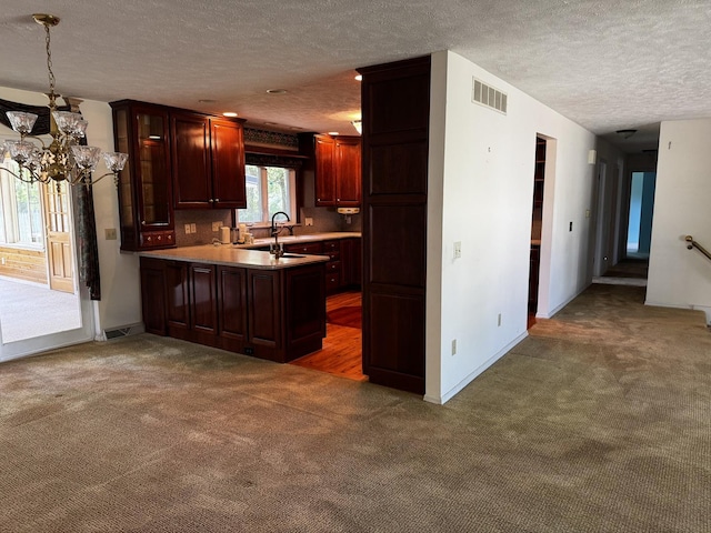 400 N Cottage Ave, Normal, IL 61761 - kitchen with a textured ceiling, carpet flooring, a chandelier, a peninsula, and light countertops