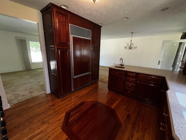 400 N Cottage Ave, Normal, IL 61761 - kitchen with paneled fridge, a chandelier, dark brown cabinets, and dark wood finished floors