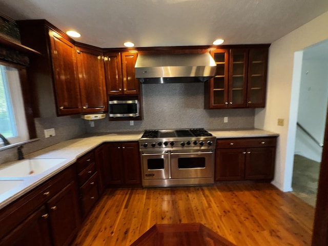 400 N Cottage Ave, Normal, IL 61761 - kitchen featuring appliances with stainless steel finishes, wall chimney range hood, light countertops, wood finished floors, and recessed lighting