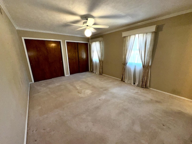 400 N Cottage Ave, Normal, IL 61761 - unfurnished bedroom with ornamental molding, multiple closets, a ceiling fan, and carpet flooring