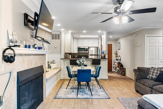 1811 Four Lakes Ave Unit 1H, Lisle, IL 60532 - dining space featuring ceiling fan, light wood finished floors, crown molding, a tile fireplace, and recessed lighting