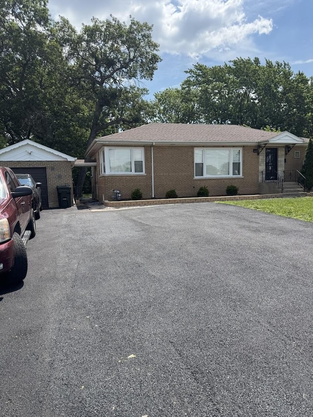 14911 Woodlawn Ave, Dolton, IL 60419 - view of front facade with brick siding, asphalt driveway, an outdoor structure, and a detached garage