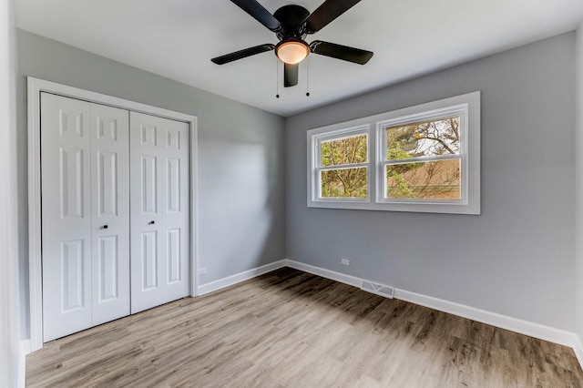 14911 Woodlawn Ave, Dolton, IL 60419 - unfurnished bedroom featuring wood finished floors, a closet, and ceiling fan