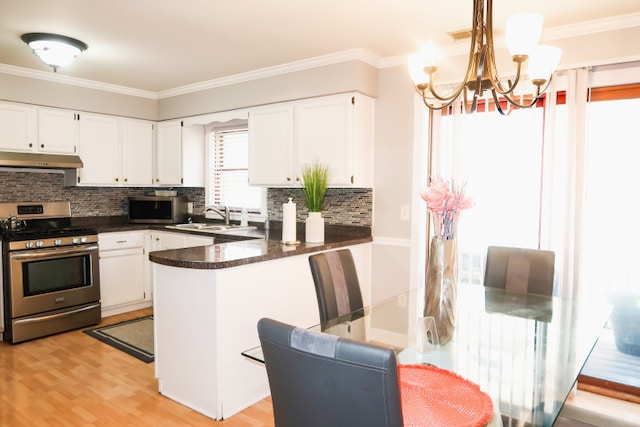 2545 N 72nd Ct Unit 4, Elmwood Park, IL 60707 - kitchen with appliances with stainless steel finishes, under cabinet range hood, dark countertops, white cabinets, and a chandelier