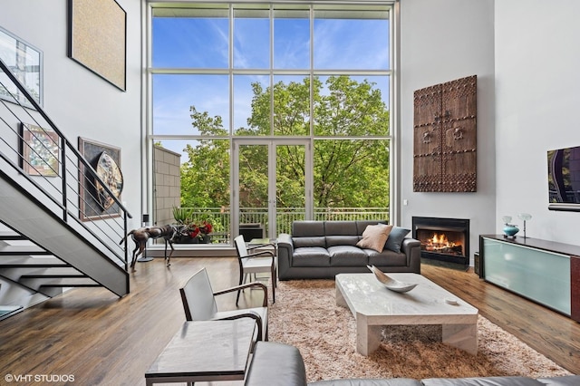 3255 N Paulina St Unit 4A, Chicago, IL 60657 - living area with floor to ceiling windows, stairs, a warm lit fireplace, and wood finished floors