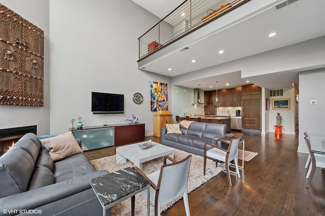 3255 N Paulina St Unit 4A, Chicago, IL 60657 - living area featuring dark wood-style floors, recessed lighting, a high ceiling, and a lit fireplace