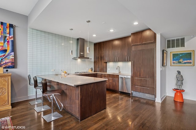 3255 N Paulina St Unit 4A, Chicago, IL 60657 - kitchen featuring stainless steel appliances, wall chimney exhaust hood, a peninsula, dark wood finished floors, and a kitchen breakfast bar