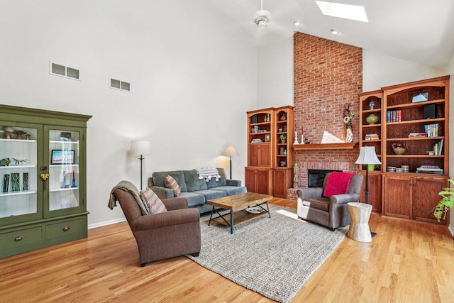 2524 Wild Timothy Rd, Naperville, IL 60564 - living room featuring high vaulted ceiling, light wood-style floors, a skylight, and a fireplace