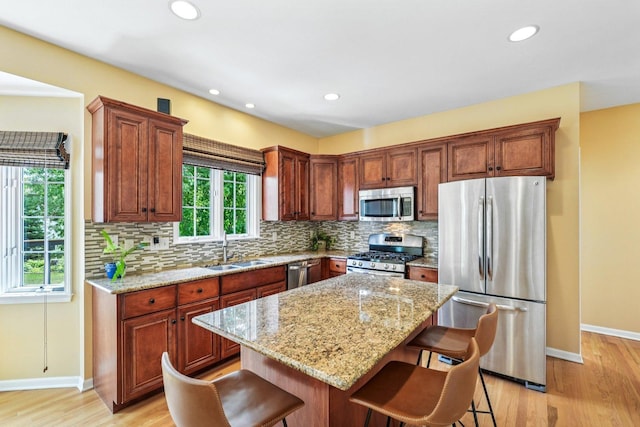 2524 Wild Timothy Rd, Naperville, IL 60564 - kitchen with appliances with stainless steel finishes, tasteful backsplash, a kitchen breakfast bar, light wood-style floors, and light stone counters