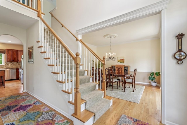 2524 Wild Timothy Rd, Naperville, IL 60564 - stairs featuring wood finished floors, arched walkways, a chandelier, and crown molding