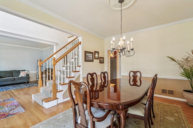 2524 Wild Timothy Rd, Naperville, IL 60564 - dining area featuring wood finished floors, stairs, crown molding, and a chandelier