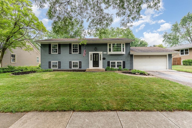 1121 S 13th St, Saint Charles, IL 60174 - split foyer home featuring asphalt driveway, an attached garage, and a front lawn