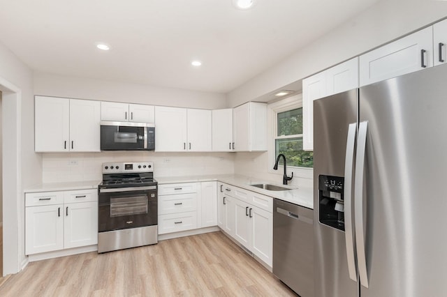 1121 S 13th St, Saint Charles, IL 60174 - kitchen with stainless steel appliances, white cabinetry, light countertops, light wood finished floors, and recessed lighting