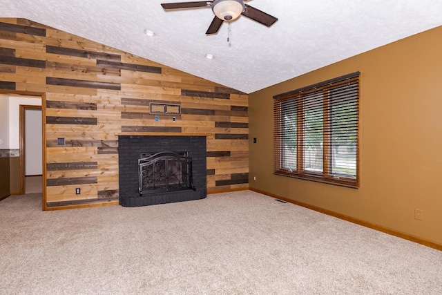 1413 Bethany Ln, Pontiac, IL 61764 - unfurnished living room featuring vaulted ceiling, a ceiling fan, wood walls, carpet flooring, and a brick fireplace