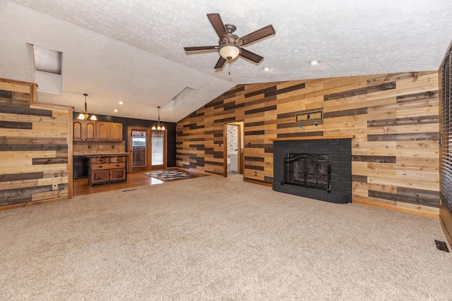 1413 Bethany Ln, Pontiac, IL 61764 - unfurnished living room featuring wooden walls, lofted ceiling, ceiling fan, carpet, and a textured ceiling