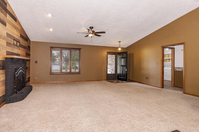 1413 Bethany Ln, Pontiac, IL 61764 - unfurnished living room featuring vaulted ceiling, ceiling fan, carpet floors, a brick fireplace, and washer / clothes dryer