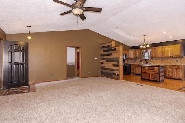 1413 Bethany Ln, Pontiac, IL 61764 - unfurnished living room with vaulted ceiling, ceiling fan, light carpet, and a skylight